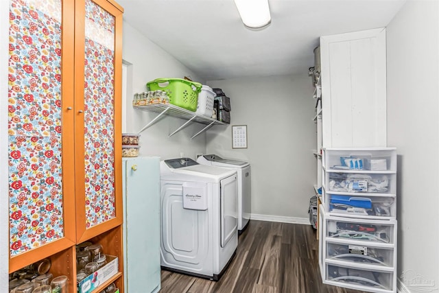 laundry room with baseboards, washer and clothes dryer, laundry area, and dark wood finished floors
