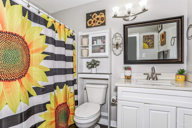 full bath featuring a shower with curtain, vanity, an inviting chandelier, and toilet