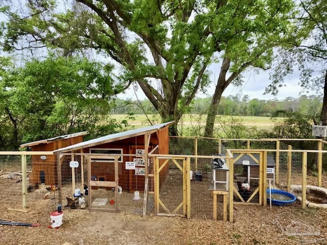 view of play area with fence, exterior structure, and an outdoor structure