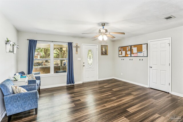 foyer entrance featuring baseboards, a ceiling fan, visible vents, and dark wood finished floors
