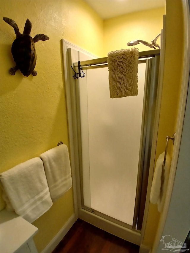 bathroom featuring wood-type flooring and a shower with shower door