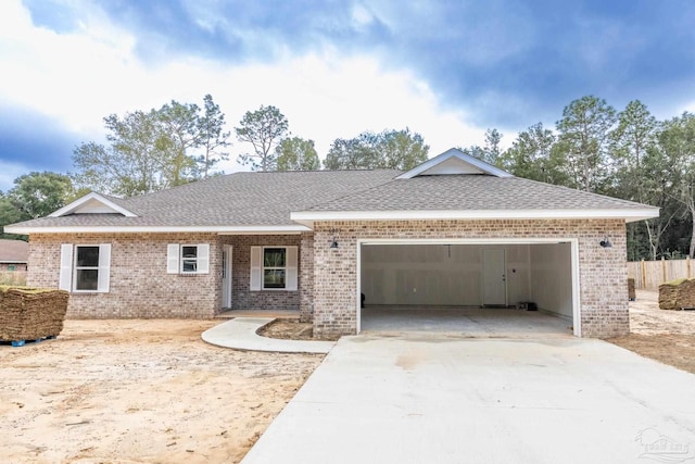 ranch-style house featuring a garage, concrete driveway, brick siding, and a shingled roof