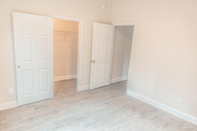 unfurnished bedroom featuring light wood-style floors, a closet, and baseboards