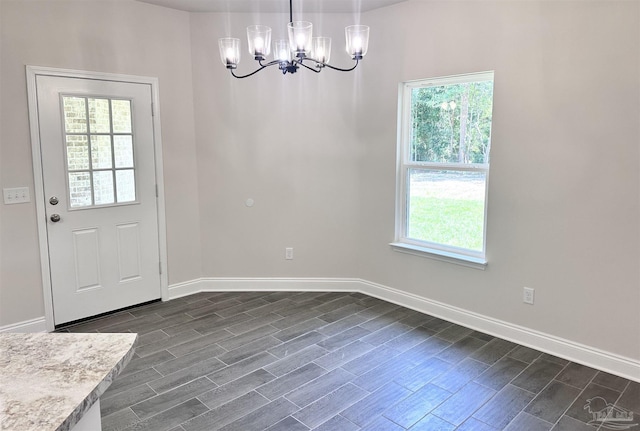 6283 Andys Ln, Milton, FL 32570 - unfurnished dining area featuring a chandelier, wood tiled floors, and baseboards