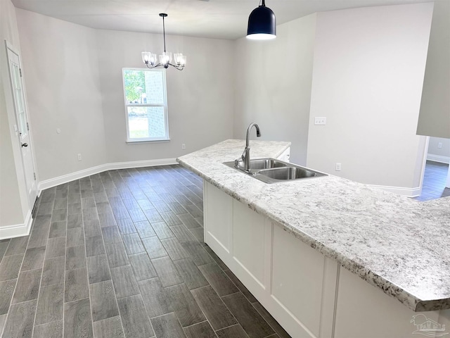 6283 Andys Ln, Milton, FL 32570 - kitchen featuring a sink, dark wood-type flooring, baseboards, a chandelier, and pendant lighting
