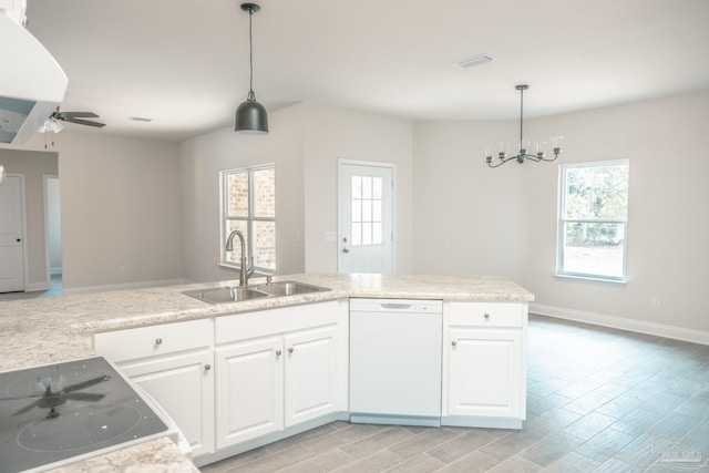 kitchen featuring pendant lighting, white cabinets, white dishwasher, a sink, and plenty of natural light