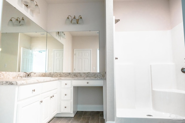 full bathroom featuring walk in shower and vanity