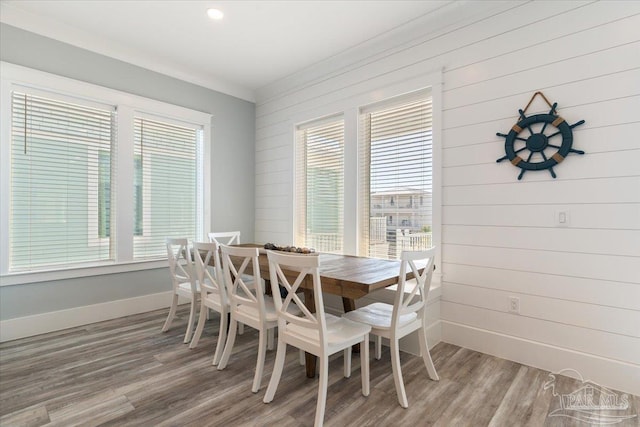 dining area featuring hardwood / wood-style flooring, a wealth of natural light, and wood walls