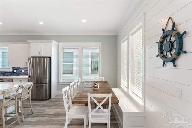 dining space featuring crown molding, plenty of natural light, breakfast area, and light hardwood / wood-style flooring