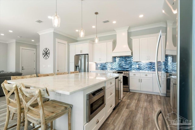 kitchen featuring dark hardwood / wood-style floors, white cabinetry, premium range hood, and stainless steel appliances