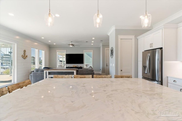 kitchen with white cabinets, decorative light fixtures, and stainless steel refrigerator with ice dispenser