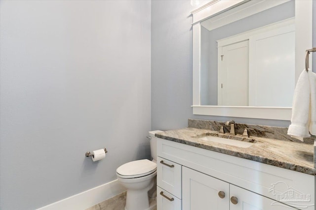 bathroom with tile patterned flooring, vanity, and toilet