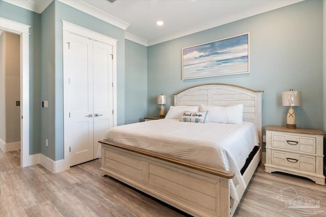 bedroom with light hardwood / wood-style flooring, a closet, and crown molding