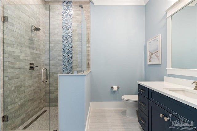 bathroom featuring tile patterned floors, vanity, toilet, and a shower with door