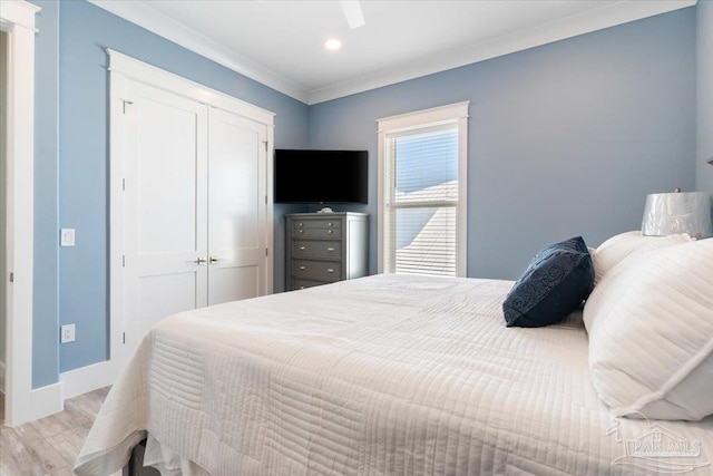 bedroom with a closet, ceiling fan, light hardwood / wood-style flooring, and ornamental molding