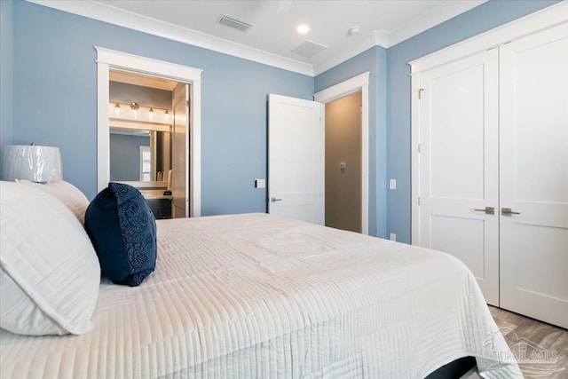 bedroom with a closet, ensuite bath, crown molding, and light hardwood / wood-style flooring