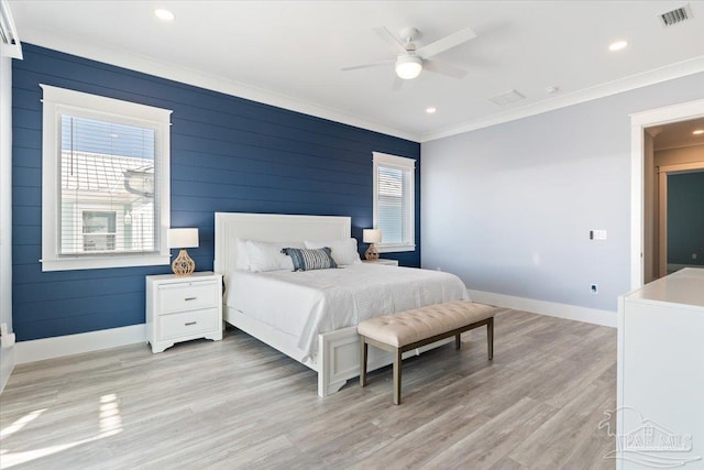 bedroom with ceiling fan, ornamental molding, wood walls, and light wood-type flooring