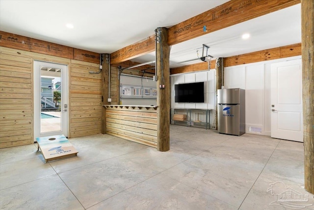 interior space featuring concrete flooring and wooden walls