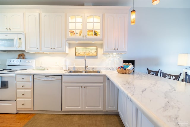 kitchen featuring pendant lighting, white appliances, white cabinetry, and sink