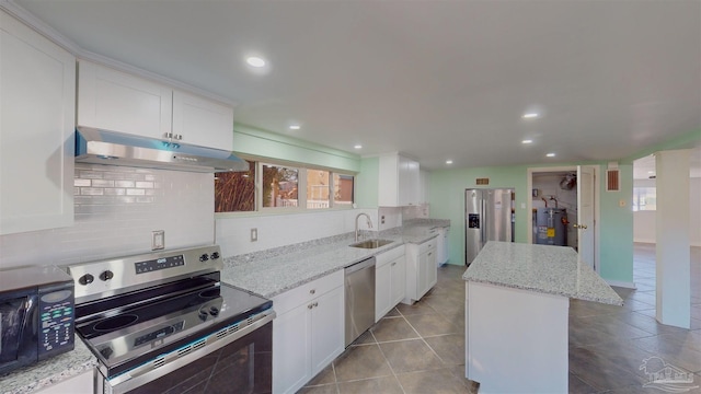 kitchen featuring light stone countertops, white cabinets, appliances with stainless steel finishes, and a kitchen island