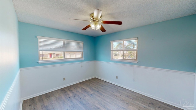 empty room featuring a textured ceiling, ceiling fan, and hardwood / wood-style flooring