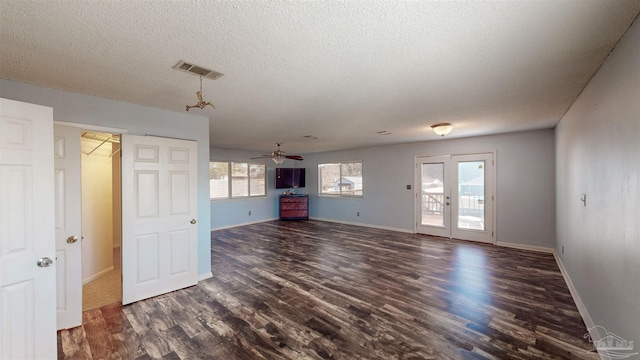 unfurnished living room with a textured ceiling, ceiling fan, and dark hardwood / wood-style flooring