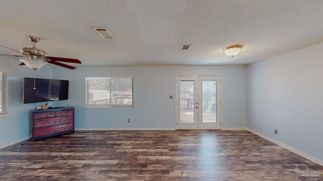 unfurnished living room with ceiling fan, plenty of natural light, dark hardwood / wood-style floors, and french doors