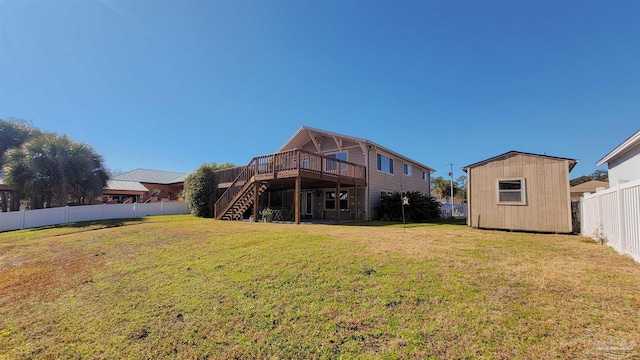 rear view of property featuring a lawn, a wooden deck, and a storage shed