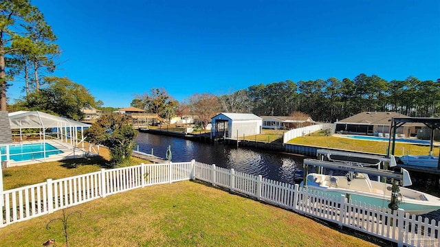 dock area featuring a fenced in pool, a water view, and a yard