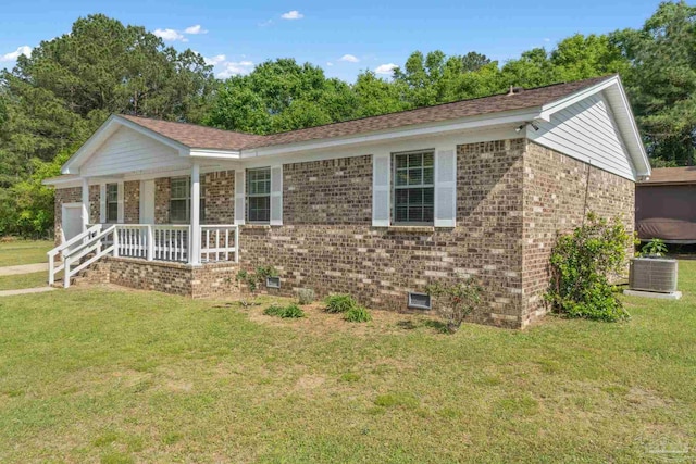 single story home featuring a front lawn, cooling unit, covered porch, a garage, and brick siding