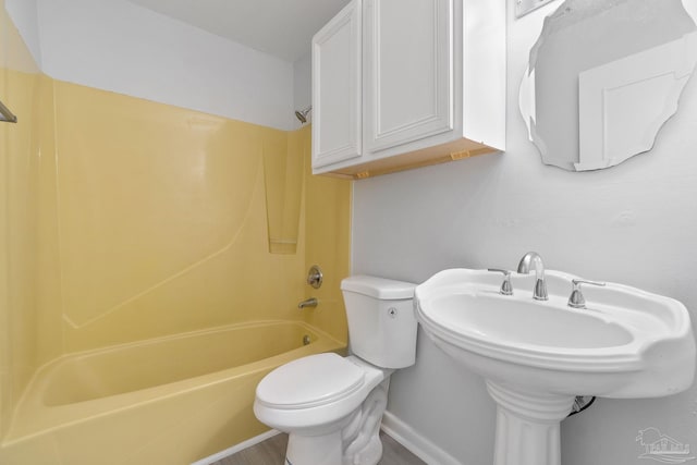 full bathroom featuring toilet, tub / shower combination, and baseboards