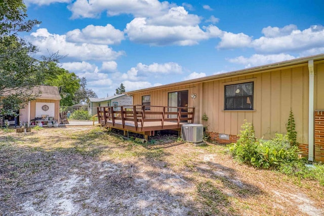rear view of property with a storage shed, central AC, a deck, board and batten siding, and crawl space