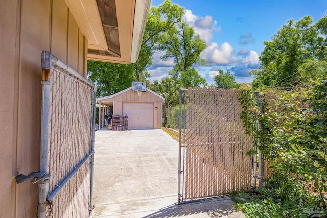 view of gate with an outbuilding and fence