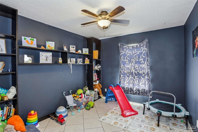 playroom featuring tile patterned floors, a ceiling fan, and a textured ceiling