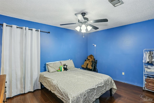 bedroom featuring wood finished floors, visible vents, and a textured ceiling