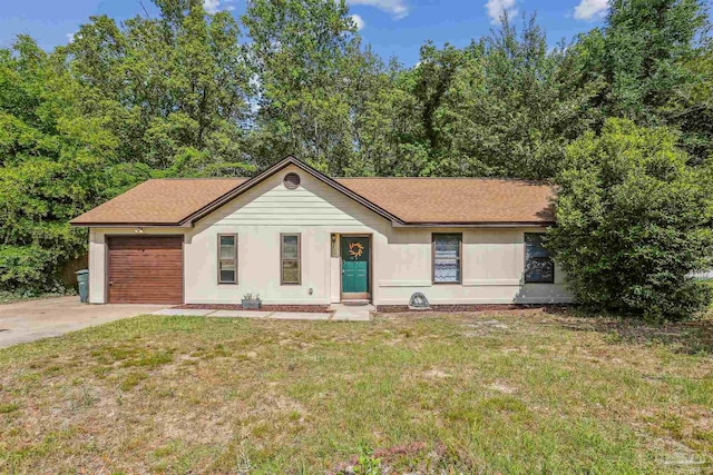 ranch-style home featuring a garage, roof with shingles, a front yard, and concrete driveway