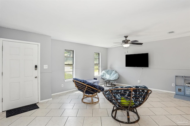 interior space with ceiling fan, baseboards, visible vents, and light tile patterned floors