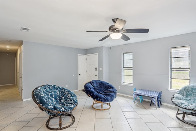 sitting room with visible vents, a ceiling fan, light tile patterned floors, and a healthy amount of sunlight