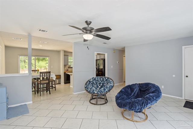 living area with visible vents, baseboards, and ceiling fan