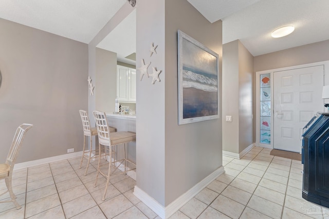 entryway with light tile patterned floors and a textured ceiling