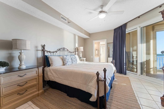 tiled bedroom featuring multiple windows, a textured ceiling, ceiling fan, and ensuite bathroom