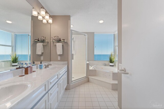 bathroom with tile patterned flooring, vanity, a textured ceiling, and separate shower and tub