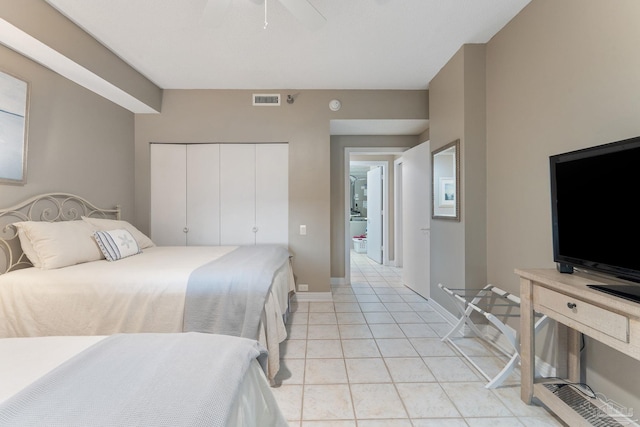 tiled bedroom with ceiling fan and a closet