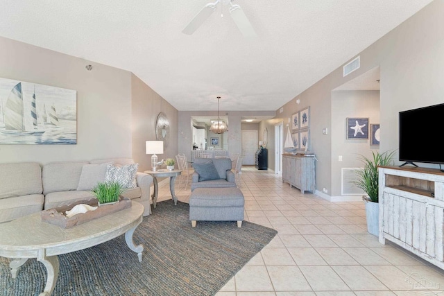 tiled living room with ceiling fan and a textured ceiling