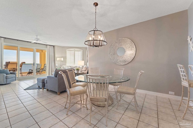 tiled dining area featuring ceiling fan with notable chandelier, plenty of natural light, and a textured ceiling