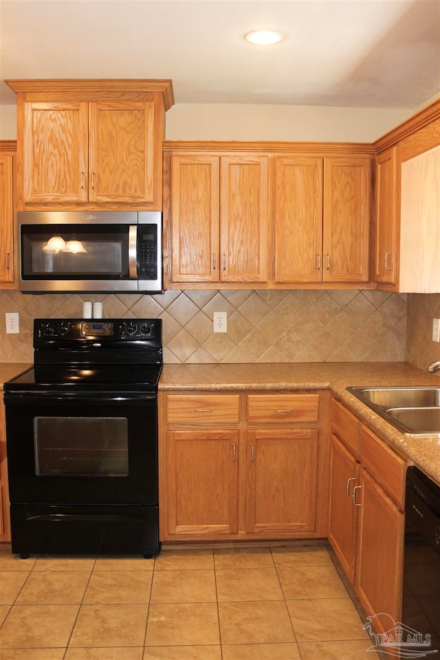 kitchen with sink, black appliances, light tile patterned flooring, and tasteful backsplash