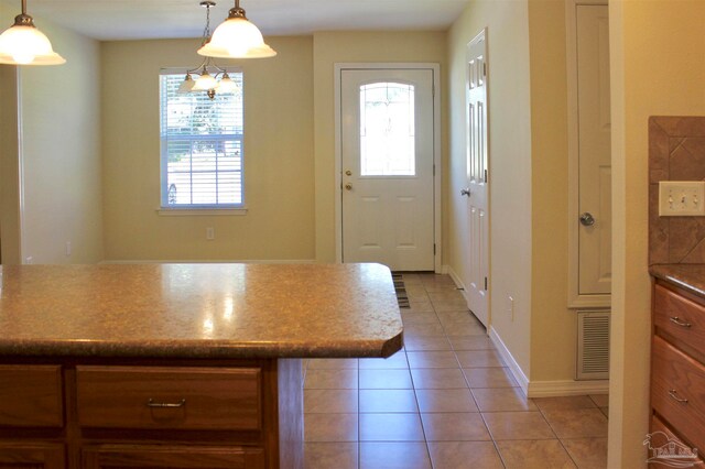 interior space with light tile patterned floors and hanging light fixtures