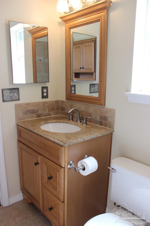 bathroom with vanity, toilet, tasteful backsplash, and tile patterned floors