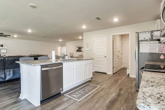 10869 Blacktail Loop, Pensacola, FL 32526 - kitchen with stainless steel dishwasher, open floor plan, white cabinets, dark wood-style flooring, and recessed lighting