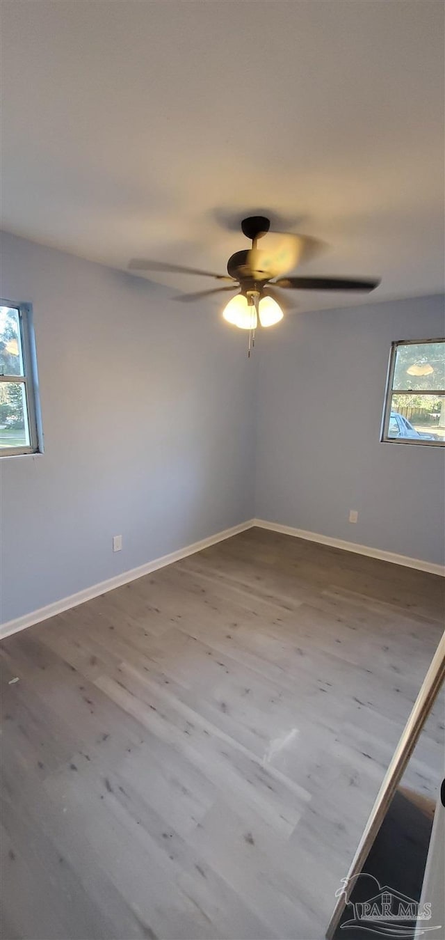 unfurnished room with hardwood / wood-style floors, plenty of natural light, and ceiling fan